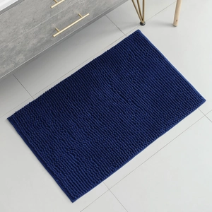 Top view of a blue rectangular chenille bath mat with soft texture in a modern bathroom