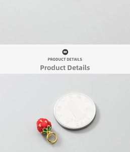 Macro shot of 925 silver gold-plated strawberry charm next to a coin for size reference