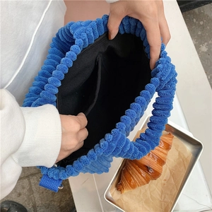 Gros plan du sac bleu à texture popcorn avec poche intérieure et fermeture éclair