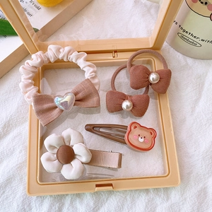 Detailed set of five brown fabric hair clips and heart scrunchies in a gift box
