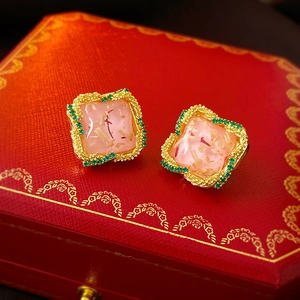 Détail macro de boucles d'oreilles vintage carrées avec résine rose et bordure cristal