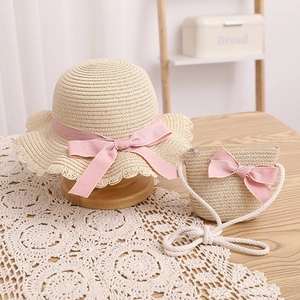 Détail de l'ensemble chapeau et sac en paille pour enfants avec nœuds roses et dentelle