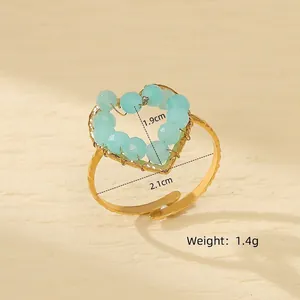 Macro shot of handmade heart ring with blue faceted beads and gold wire wrap details