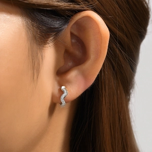 Macro shot of 925 sterling silver wavy hoop earrings with pavé set cubic zirconia