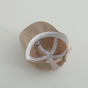 Interior view of khaki boys baseball cap with smile embroidery and adjustable buckle