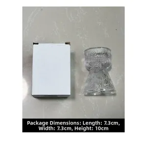 Detail view of transparent ribbed glass candle holder beside its white packaging box