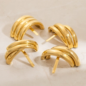 Close-up of golden metallic hair clips with a curved triple-layer tube design