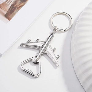 Close-up of a silver metal airplane keychain with an integrated bottle opener feature