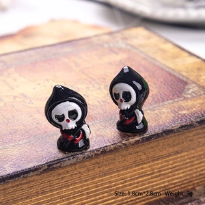 Detailed view of two 1.8x2.8cm miniature reaper figurines with scythes on vintage books