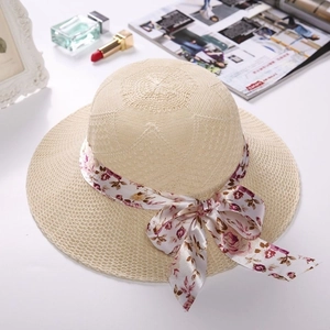 Elegant beige straw sun hat with floral ribbon bow and wide brim for summer travel