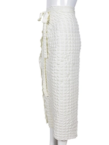 Detail of high waist white skirt featuring textured bubble fabric and side drawstring