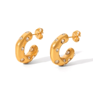 Close-up of gold-plated C-shaped stainless steel earrings with sparkling zircon inlay