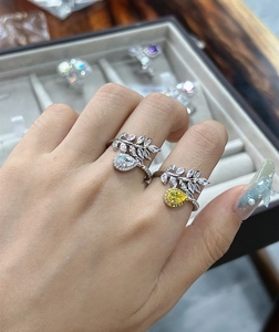 Macro detail of leaf-shaped silver ring with waterdrop diamond worn on hand