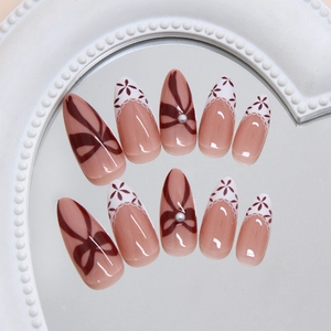Faux ongles amande français avec nœuds rouges, dentelle blanche et perles