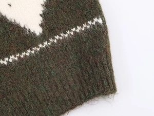 Detailed macro shot of olive green mohair knit cardigan with white jacquard pattern