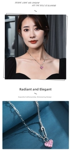 Detail view of pink heart crystal pendant with silver paperclip chain on female model