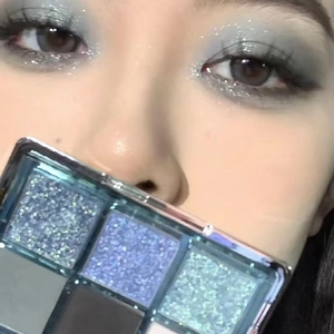 Close-up of nine-color eyeshadow palette makeup with blue and silver glitter shades