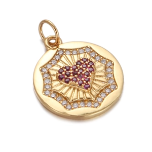 Close-up of a gold circular pendant featuring a red zircon heart and clear halo stones