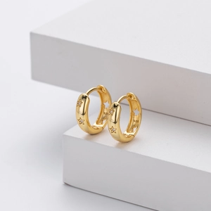 Detailed macro view of gold plated S925 silver hoop earrings with hollow stars and small gems