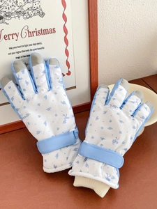 Detail of blue floral ski gloves showing touch screen tips and adjustable wrist straps