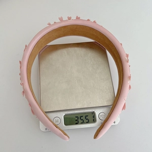 Pink heart sponge headband weighing 35.51g shown on an electronic scale for accuracy