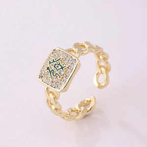 Detail of 18K gold ring featuring a green enamel Chinese character and pave zircons