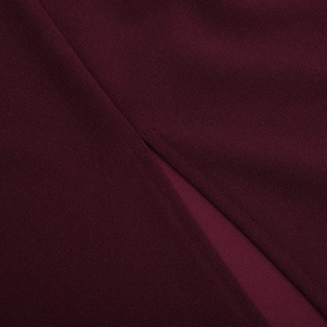 Gros plan du tissu de la robe sans manches bordeaux montrant texture et détails de couture