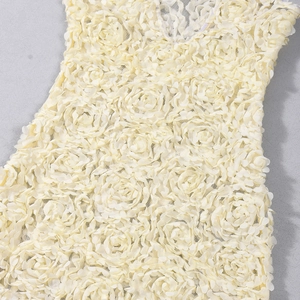 Detail aus 3D-Blumenspitze und Netzstoff an einem schmalen V-Ausschnitt-Kleid in Beige