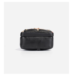 Close-up of black leather backpack base with gold metal rivets and detailed texture