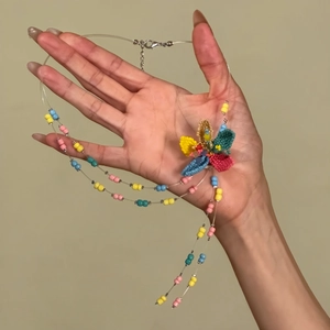 Handcrafted colorful glass bead necklace with intricate 3D floral design detail.