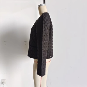 Side view of black quilted jacket featuring diamond pattern stitching and sleek silhouette
