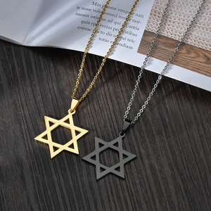 Minimalist hexagram star pendant necklace in gold and silver steel on wood background
