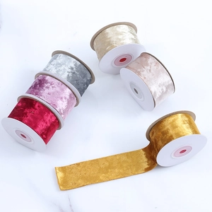 Premium velvet ribbon rolls in assorted colors for DIY Christmas bows on marble background