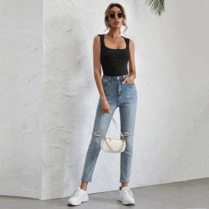 Close-up of black U-neck slim fit tank top paired with light blue ripped denim jeans
