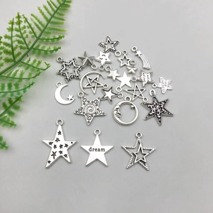 Antique silver star and moon charms set with hollow designs and engraved lettering
