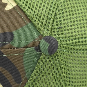 Close-up of camouflage cotton fabric and breathable mesh with a top button on a baseball cap