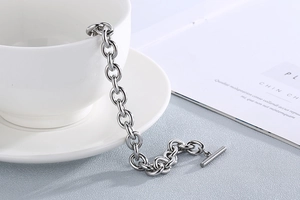 Detailed view of silver stainless steel OT buckle chunky chain bracelet on white ceramic