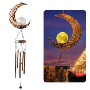 Detail showing solar moon wind chime with crackle glass ball glowing in warm yellow light