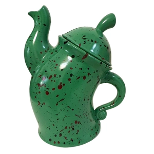 Close-up of green ceramic canister with attitude featuring red and black spotted glaze pattern