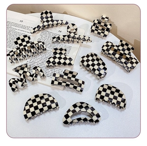 Close-up of vintage black and white checkered hair claw clips on an English book