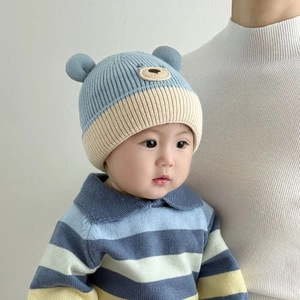 Detail of baby winter knit hat with 3D bear ears and cute embroidered animal face