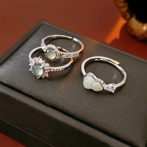 Detailed close-up of three silver-tone adjustable rings with jade-like stones and zircons