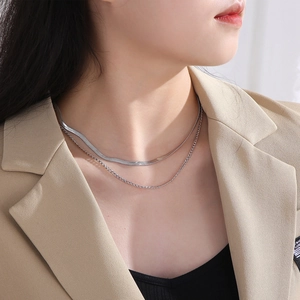 Detail of silver double-layer stainless steel necklace featuring flat blade and fine link chain