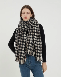 Macro view of thick houndstooth scarf with frayed edges and oversized knitted texture