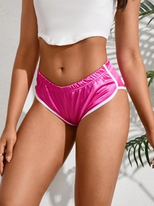 Dettaglio di pantaloncini sportivi in raso fucsia con bordi bianchi a contrasto