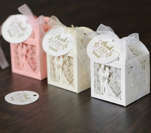 Laser cut wedding favor boxes in white and pink with ribbons and thank you tags