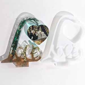 Detailed view of DIY resin LOVE frame mold with finished glitter heart photo display