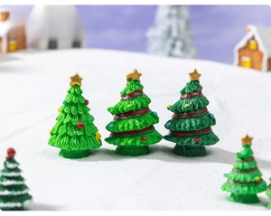 Detailed view of resin Christmas tree miniatures with golden stars and colorful beads