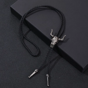 Detail of western vintage bull skull bolo tie with black braided leather and silver tips