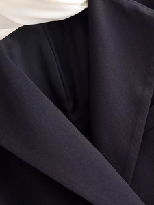 Detailed macro view of navy blue twill suit fabric with white lapel stitching detail